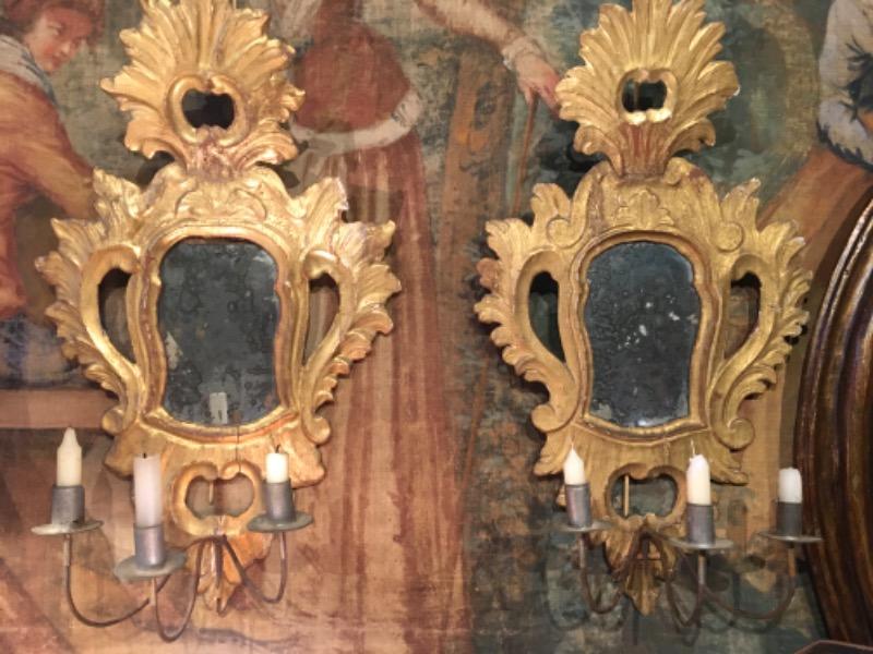 Paire de miroirs vénitiens en bois doré d’epoque 18 ème avec 3 bras de lumière en métal